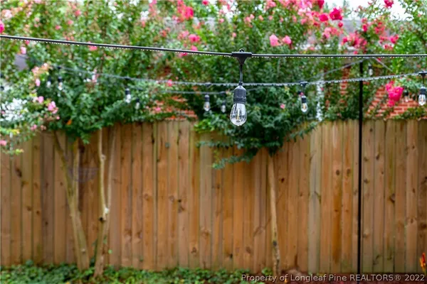 a backyard of a house with table and chairs and wooden fence