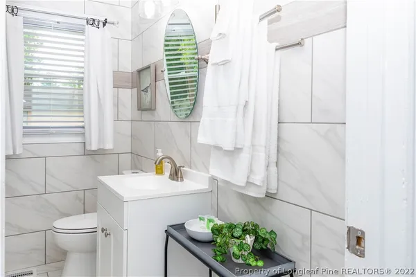 a bathroom with a sink a toilet and a mirror