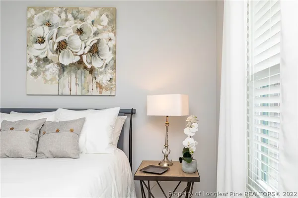 a bed room with a bed and a painting on the wall