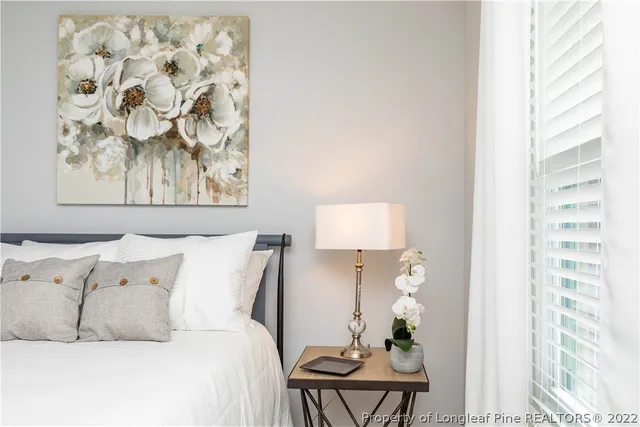 a bed room with a bed and a painting on the wall