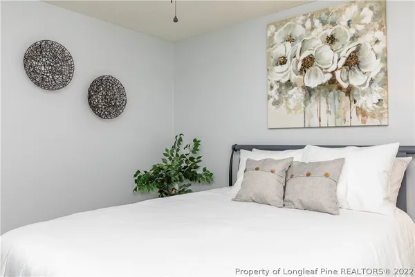 a white bed sitting in a bedroom next to a window