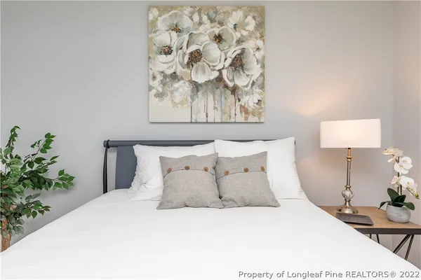 a large bed sitting in a bedroom next to a lamp