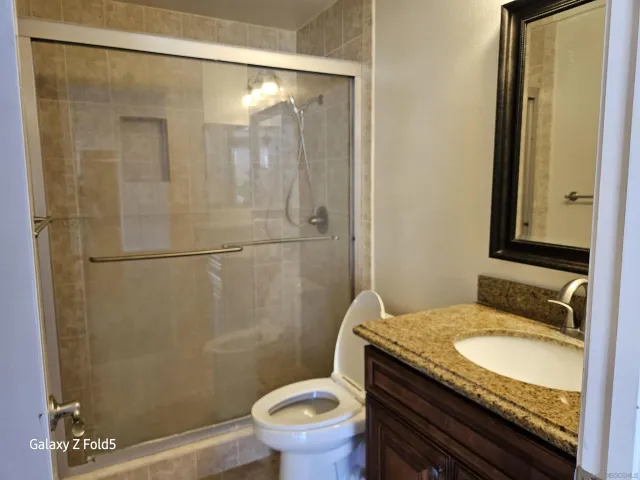 a bathroom with a granite countertop sink toilet and shower