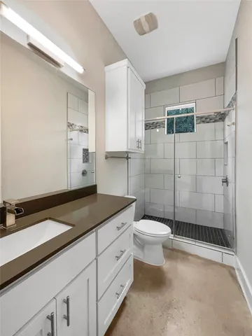 a bathroom with a granite countertop sink toilet and shower