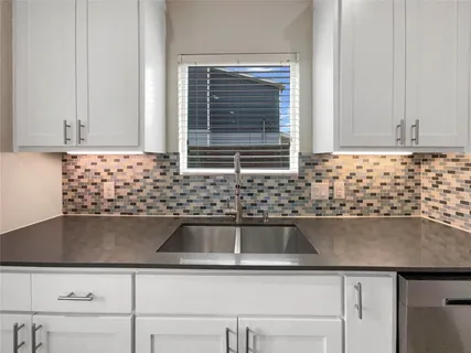 a kitchen with granite countertop a refrigerator and a stove top oven