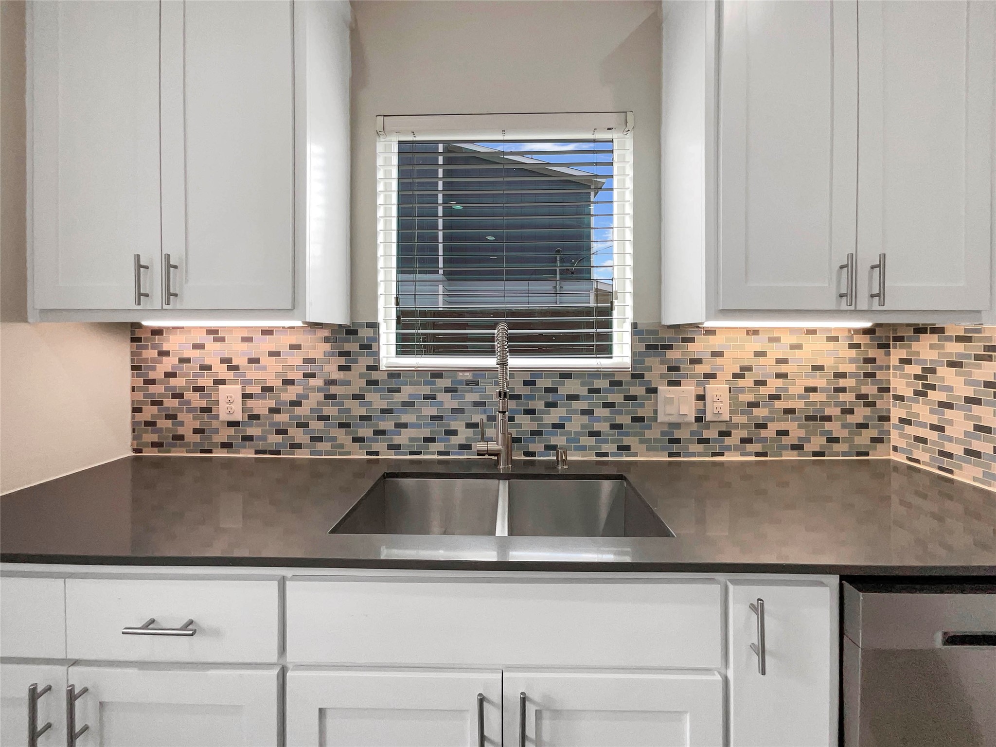 6213 Felix Avenue, Unit B Austin, TX 78741 - Photo 6 of 21 Kitchen featuring white cabinets, tasteful backsplash, dark stone counters, and dishwasher