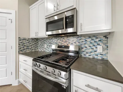 a kitchen with granite countertop a sink and a stove