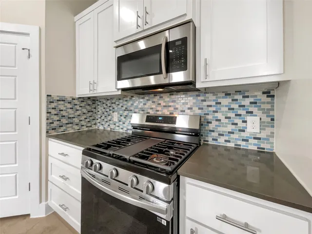 a kitchen with granite countertop a sink and a stove