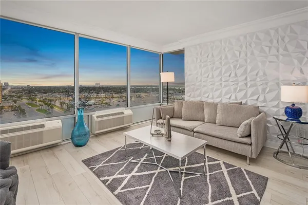 a living room with furniture and a floor to ceiling window