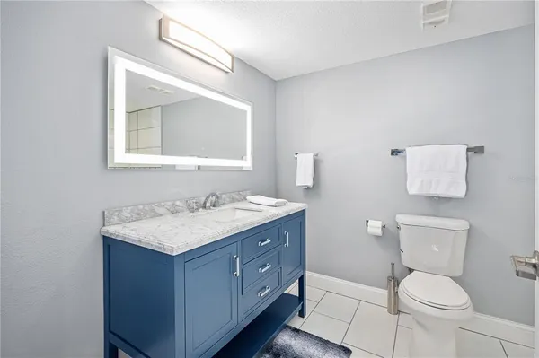 a bathroom with a toilet a sink a vanity and mirror