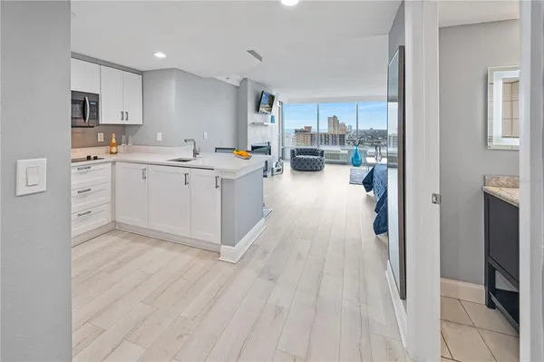 a kitchen with white cabinets and sink