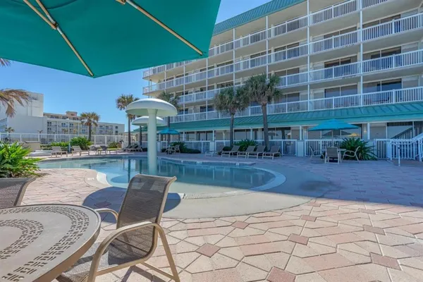 a view of a patio with a table and chairs under an umbrella