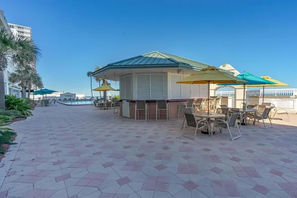 a view of a patio with a table and chairs under an umbrella