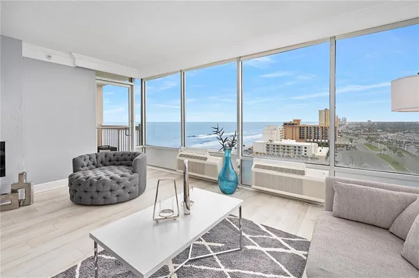 a living room with furniture and floor to ceiling window