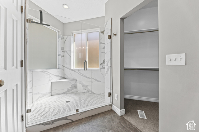 14038 New Saddle Road Draper, UT 84020 - Photo 14 of 46 Walk-in shower with clear glass enclosure, white marble-look tile walls, integrated shower bench, and white hexagonal floor tiles