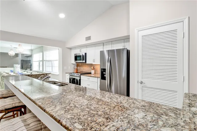 a kitchen with stainless steel appliances granite countertop a refrigerator and a sink