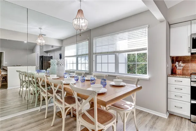a view of a dining room with furniture a chandelier and wooden floor