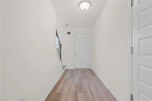 a view of a room with wooden floor and white walls