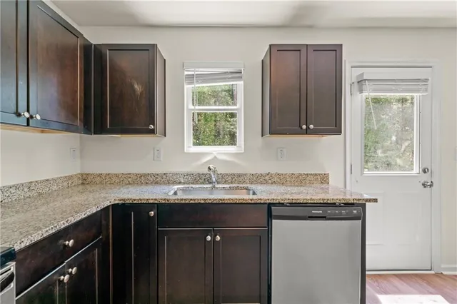 a kitchen with granite countertop a sink stove and cabinets