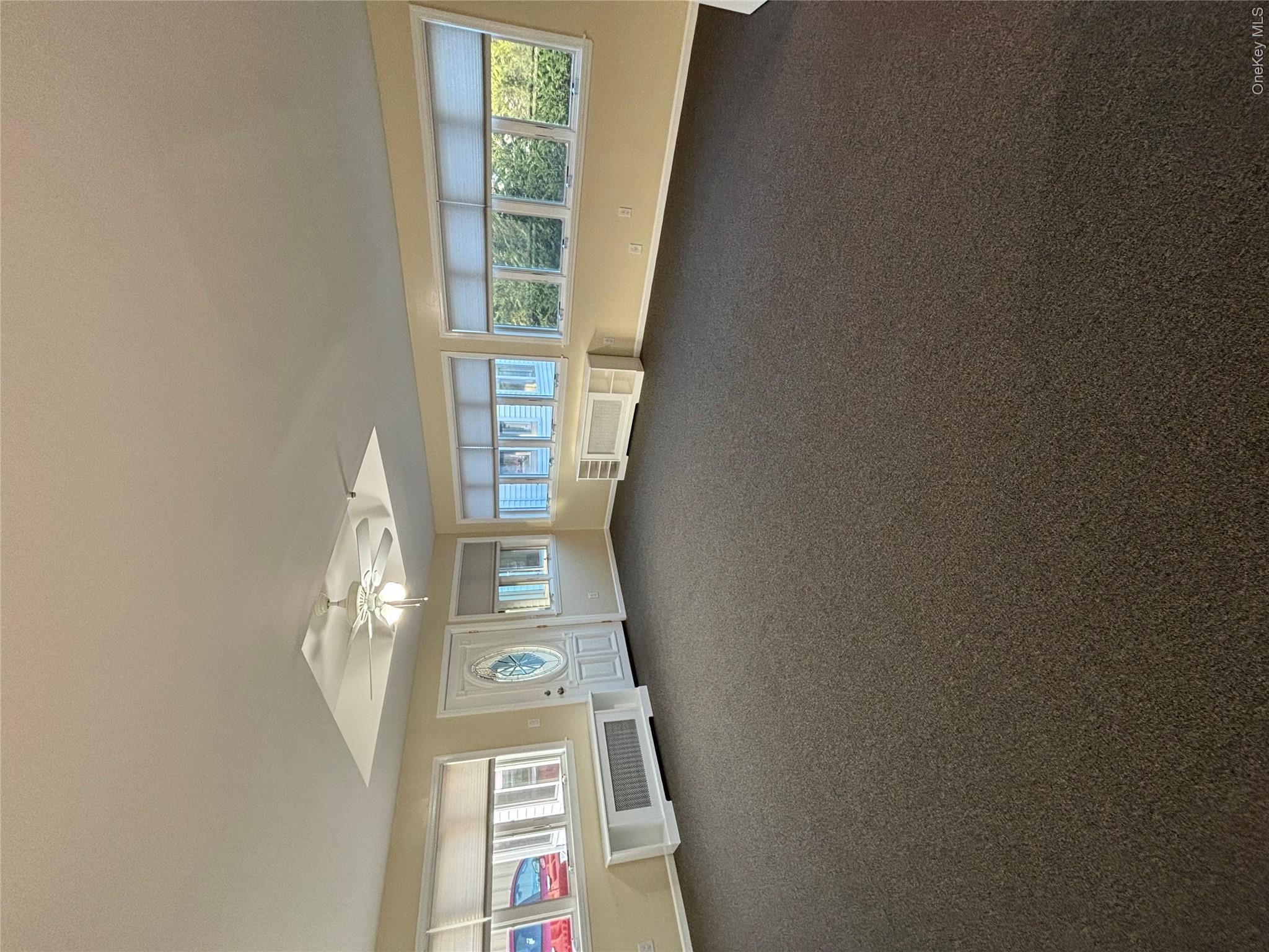 445 North Country Road St. James, NY 11780 - Photo 2 of 13 an empty room with a fireplace and large window