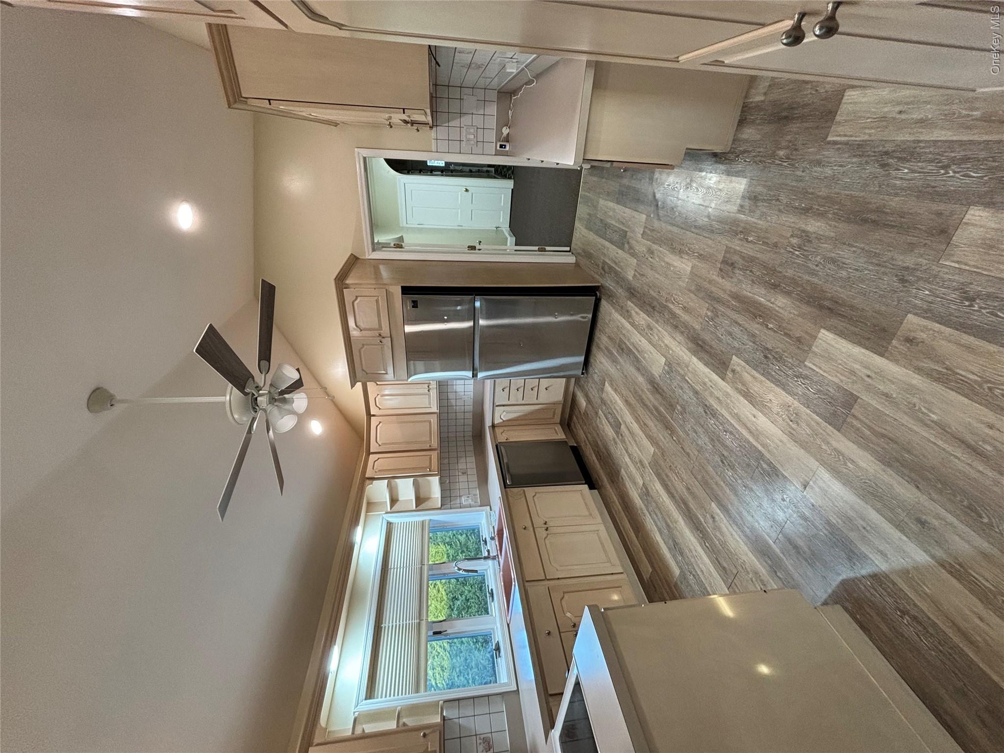 445 North Country Road St. James, NY 11780 - Photo 6 of 13 a view of a kitchen with a sink and a refrigerator
