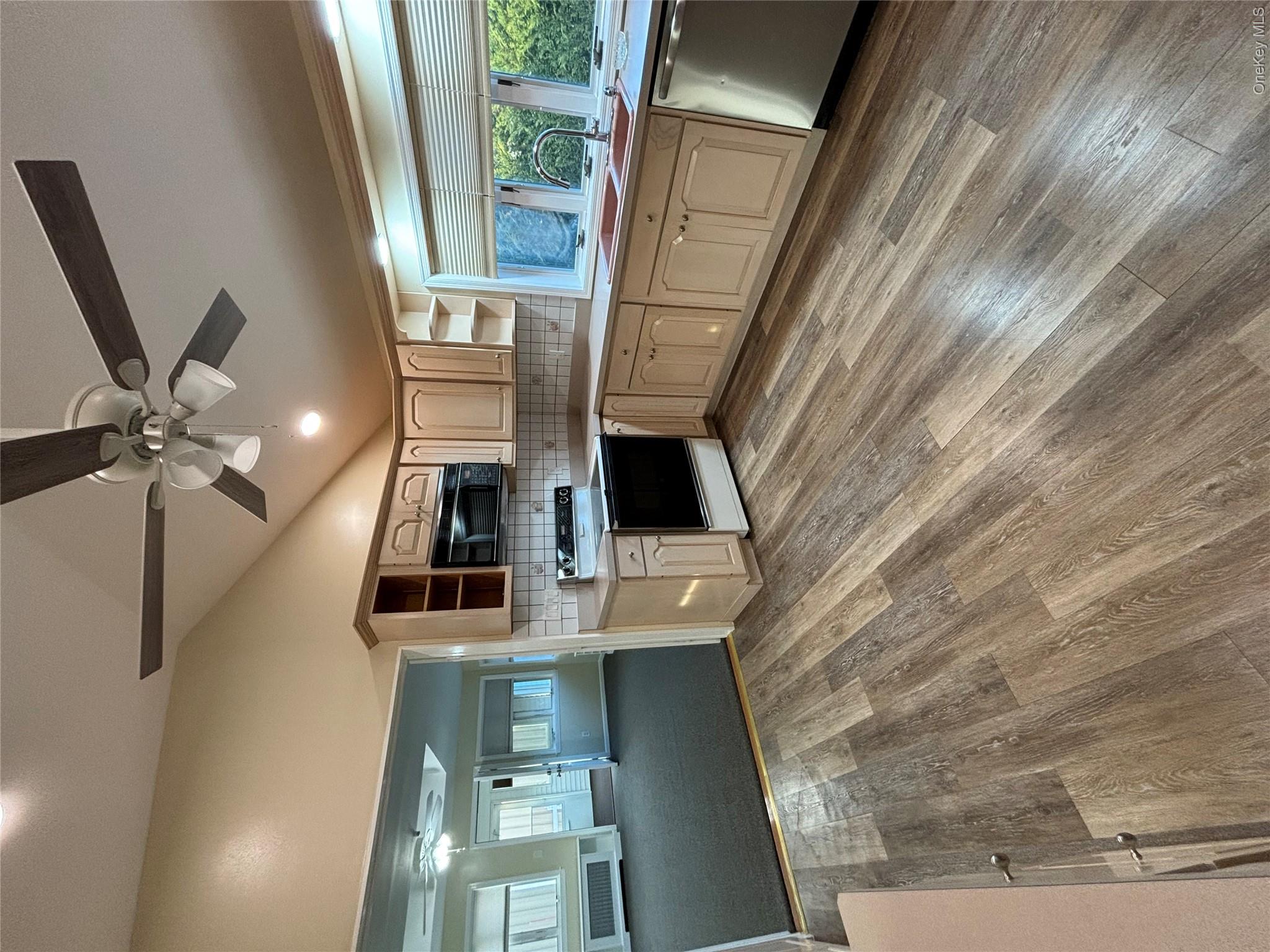 445 North Country Road St. James, NY 11780 - Photo 7 of 13 a large kitchen with kitchen island a stove a sink dishwasher a dining table and chairs with wooden floor