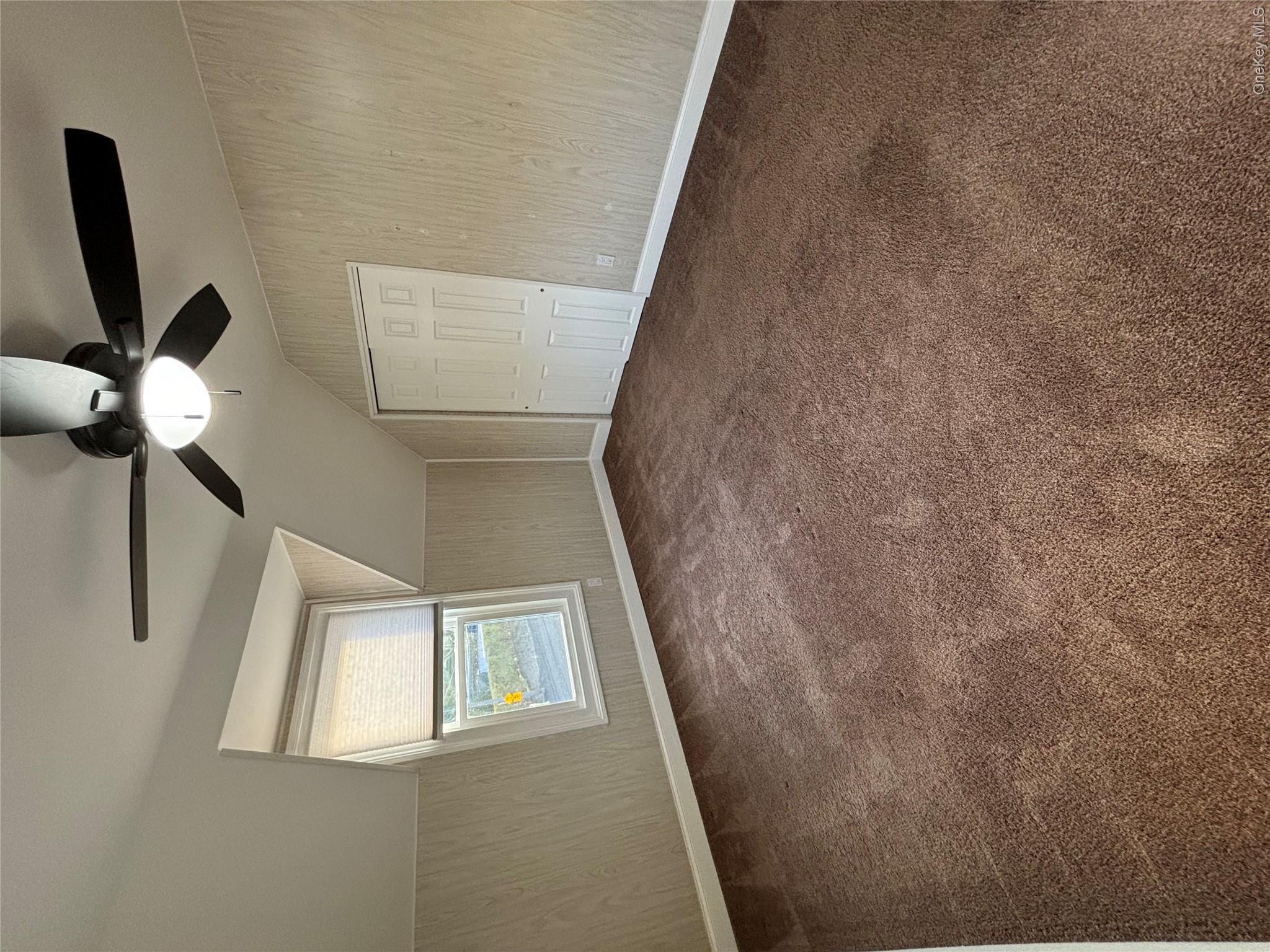 445 North Country Road St. James, NY 11780 - Photo 10 of 13 an empty room with windows and fan