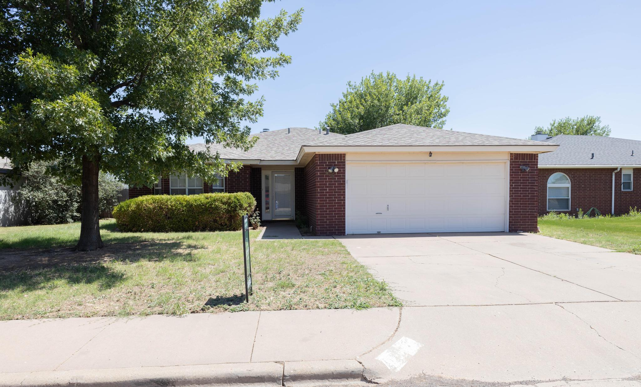 6115 8th Street Lubbock, TX 79416 - Photo 1 of 18 a front view of a house with garden