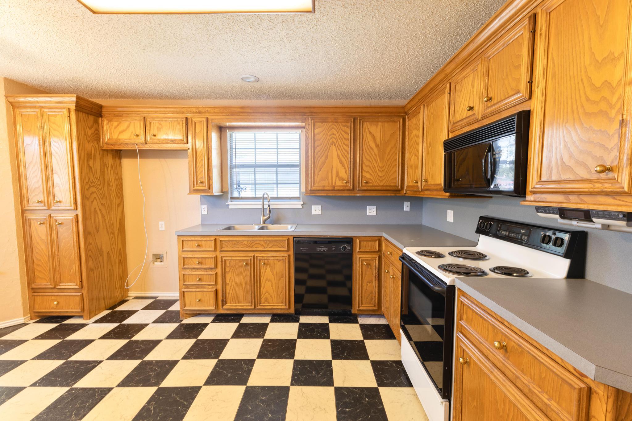6115 8th Street Lubbock, TX 79416 - Photo 3 of 18 a kitchen with a stove a sink and a microwave