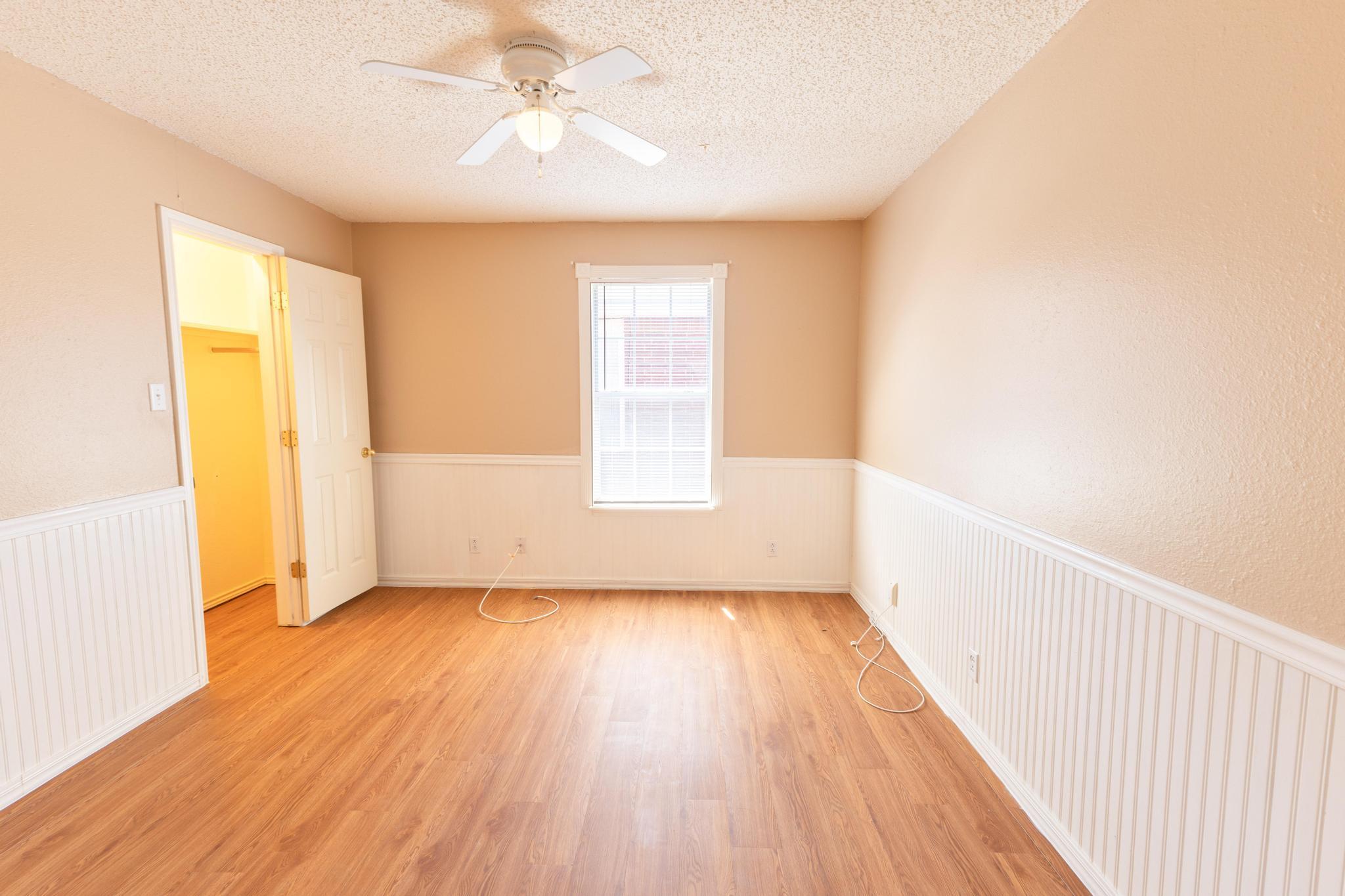 6115 8th Street Lubbock, TX 79416 - Photo 7 of 18 a view of an empty room with wooden floor and a window