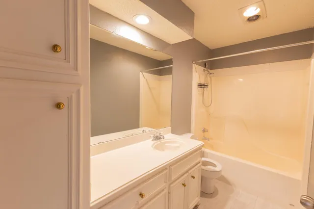 a bathroom with a granite countertop sink a mirror and a shower