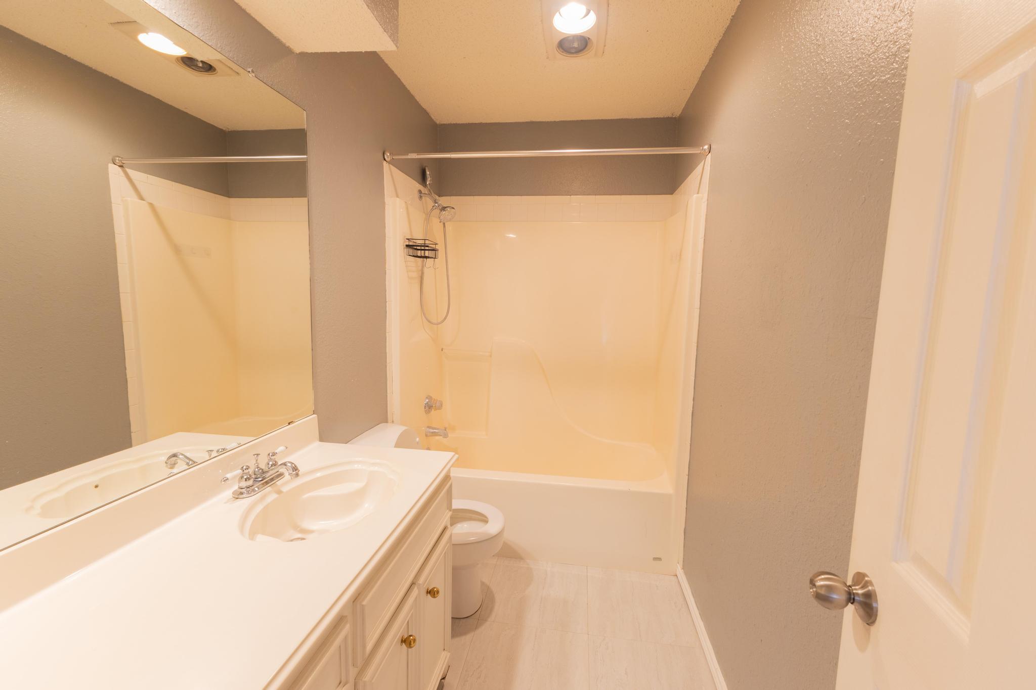 6115 8th Street Lubbock, TX 79416 - Photo 9 of 18 a bathroom with a sink and a mirror
