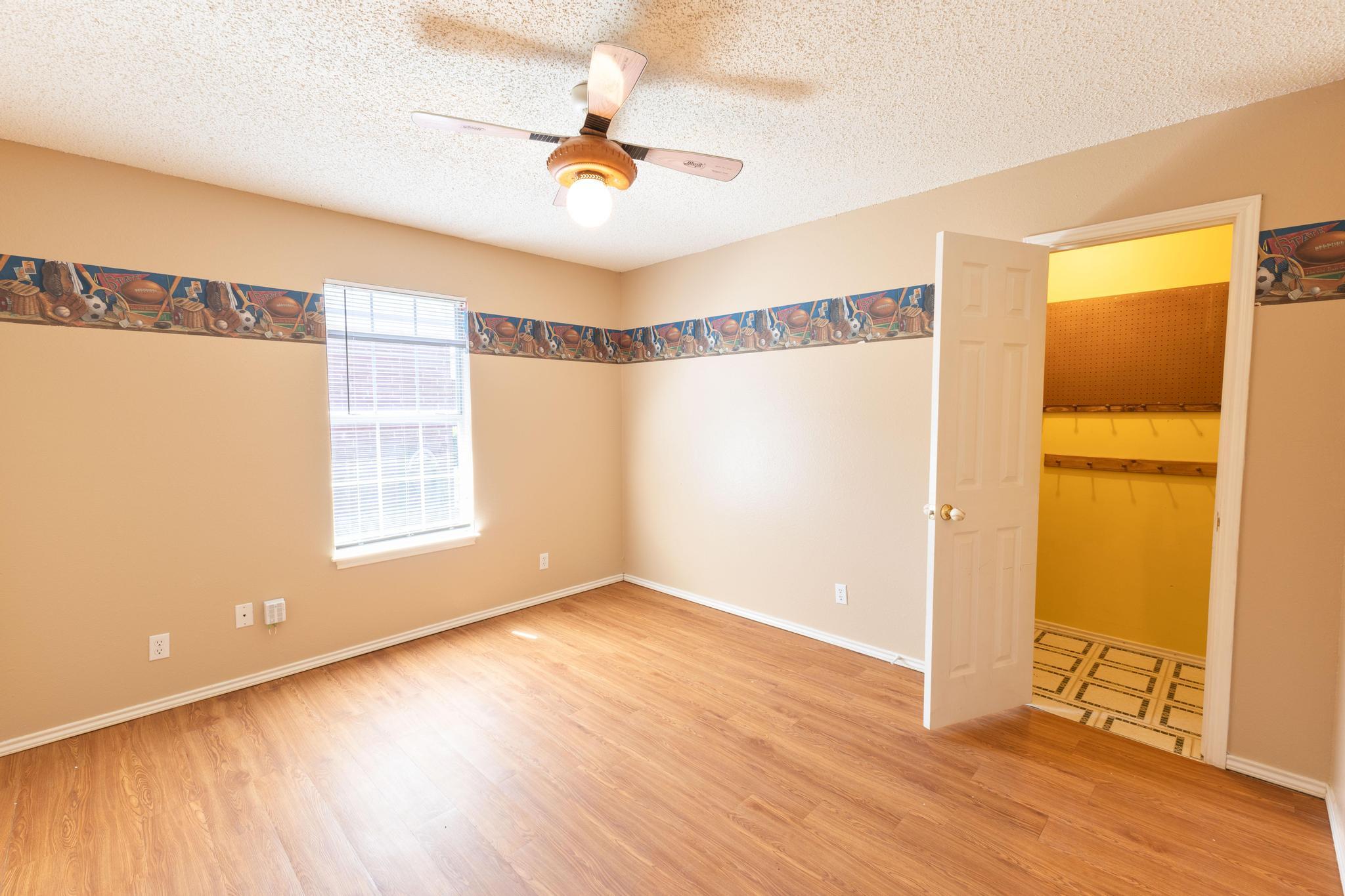 6115 8th Street Lubbock, TX 79416 - Photo 10 of 18 a view of an empty room with wooden floor and a window