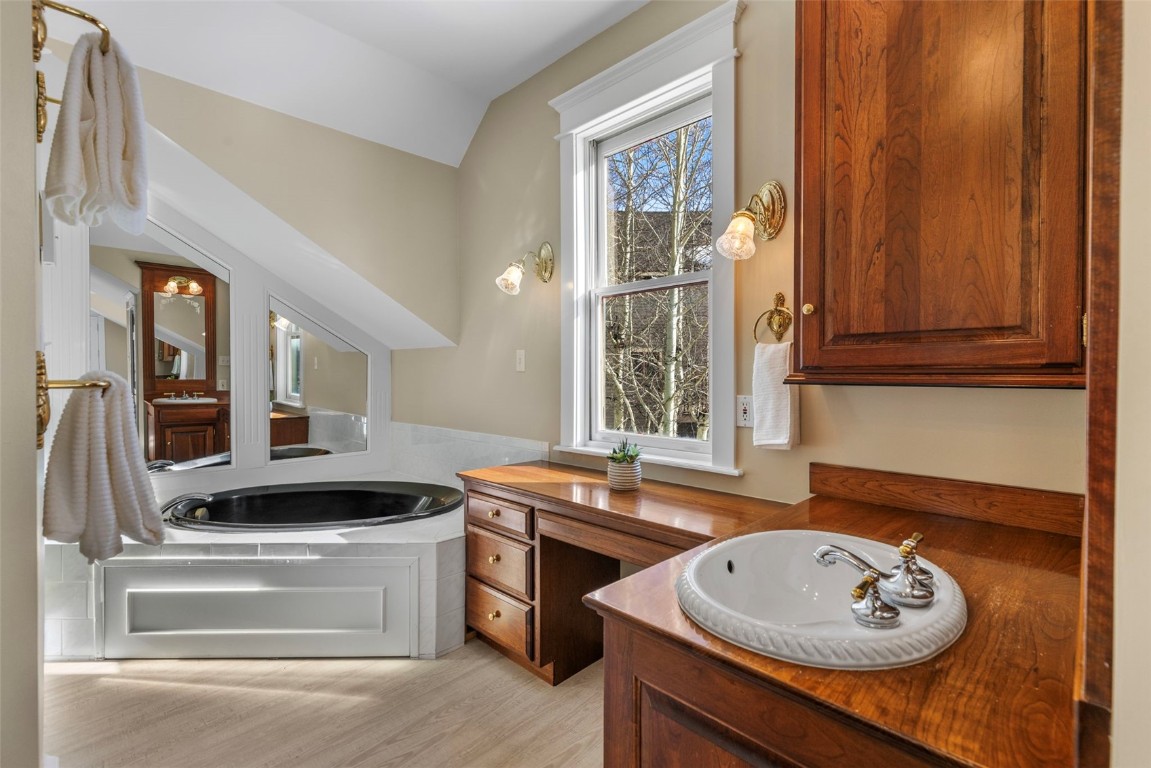 192 Wellington Road Breckenridge, CO 80424 - Photo 28 of 50 Bathroom featuring a garden tub, vaulted ceiling, light wood-type flooring, and vanity