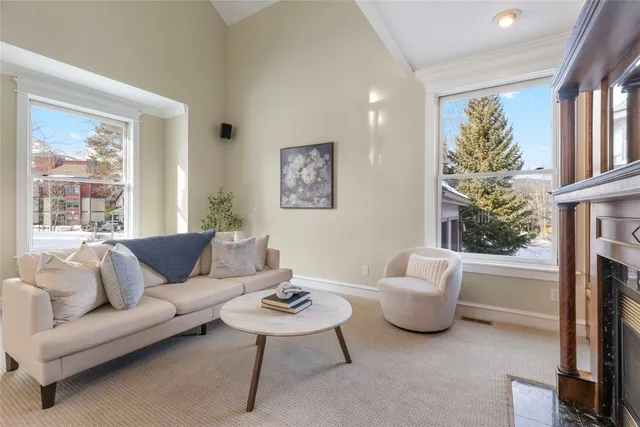 a living room with furniture a fireplace and a large window