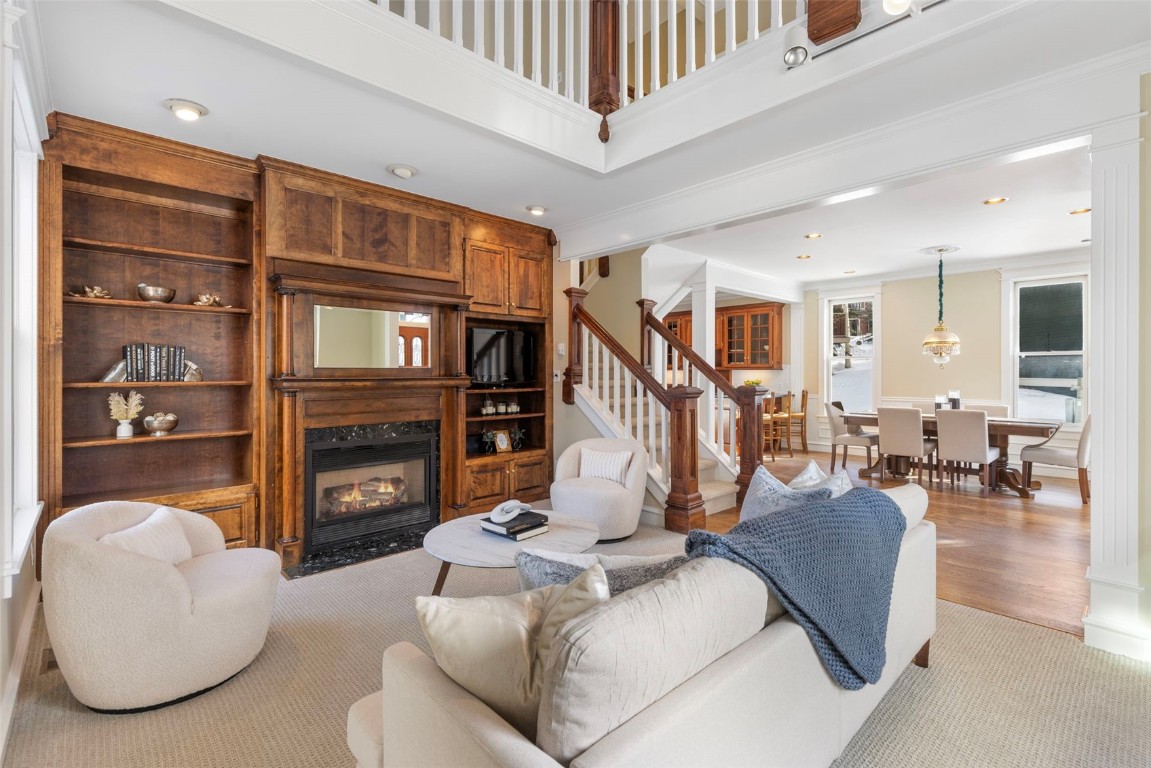 192 Wellington Road Breckenridge, CO 80424 - Photo 4 of 50 Carpeted living area featuring a fireplace with flush hearth, ornamental molding, recessed lighting, built in features, and ornate columns