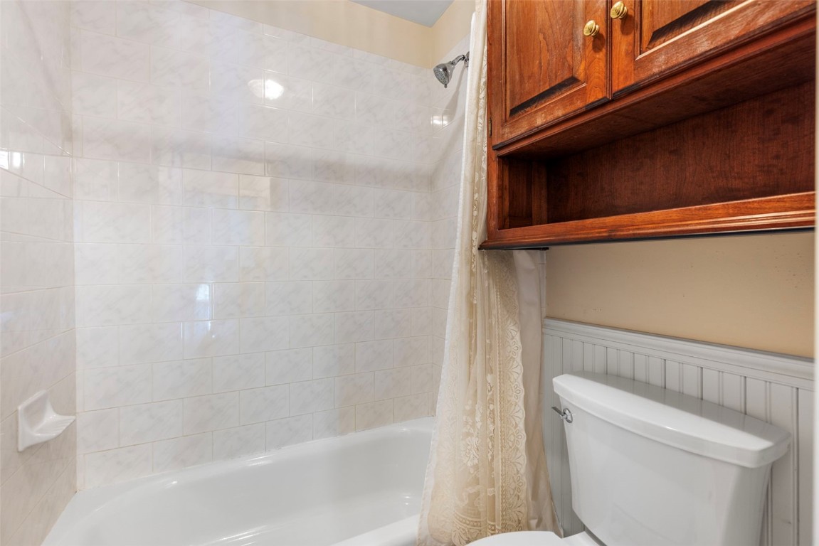 192 Wellington Road Breckenridge, CO 80424 - Photo 41 of 50 Full bathroom featuring wainscoting, shower / bath combo with shower curtain, and a decorative wall
