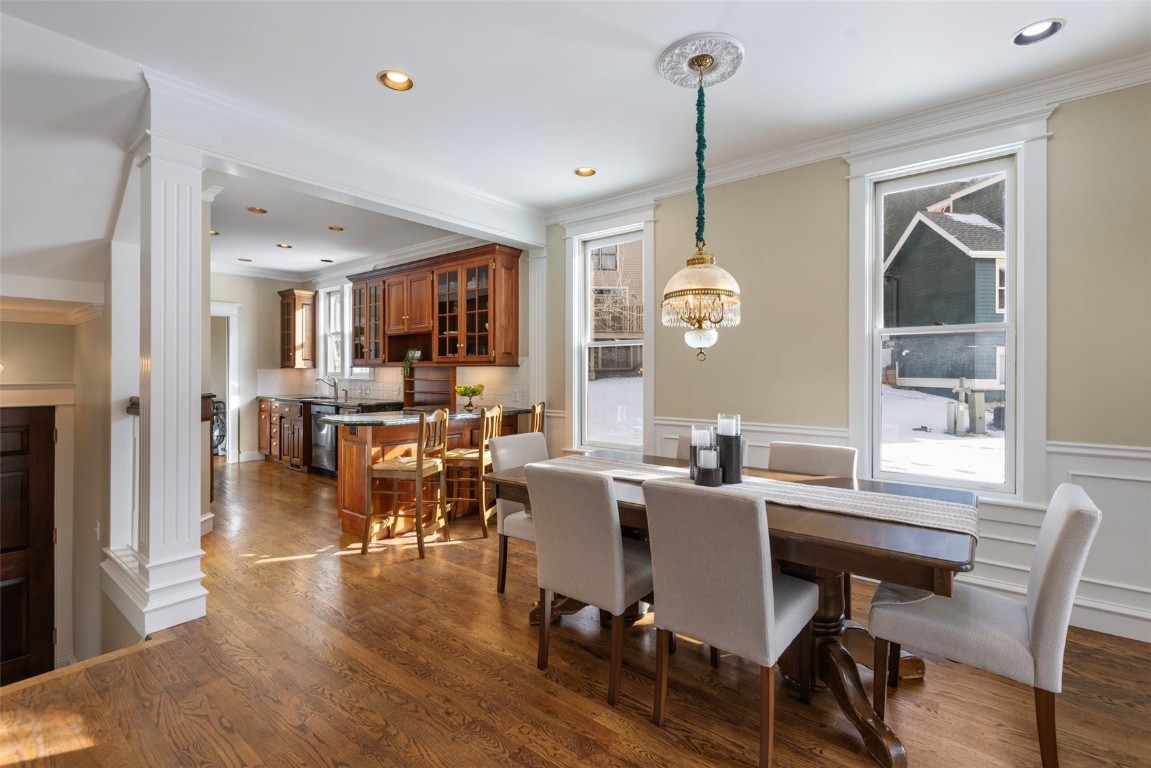 192 Wellington Road Breckenridge, CO 80424 - Photo 7 of 50 Dining area featuring ornamental molding, dark wood-style floors, decorative columns, recessed lighting, and a wainscoted wall
