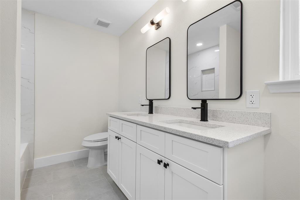 2816 Quail Ridge Drive Carrollton, TX 75006 - Photo 17 of 33 Bathroom featuring double vanity, light tile patterned flooring, and shower / tub combination