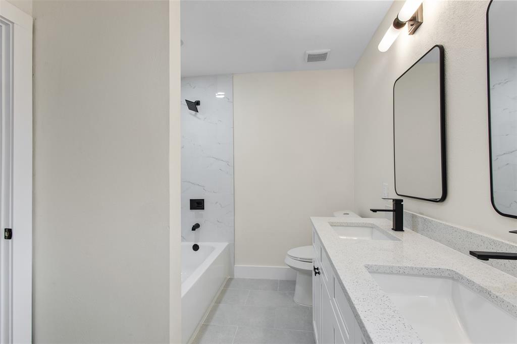 2816 Quail Ridge Drive Carrollton, TX 75006 - Photo 18 of 33 Bathroom with shower combination, double vanity, and light tile patterned flooring