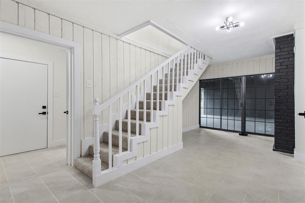 2816 Quail Ridge Drive Carrollton, TX 75006 - Photo 22 of 33 Stairs with wood walls and tile patterned flooring