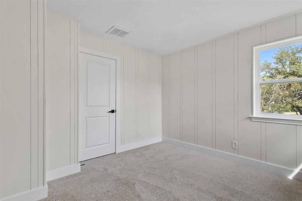 2816 Quail Ridge Drive Carrollton, TX 75006 - Photo 25 of 33 Spare room featuring light carpet and a decorative wall