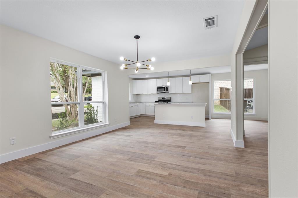 2816 Quail Ridge Drive Carrollton, TX 75006 - Photo 7 of 33 Unfurnished living room featuring a chandelier and light wood-style floors