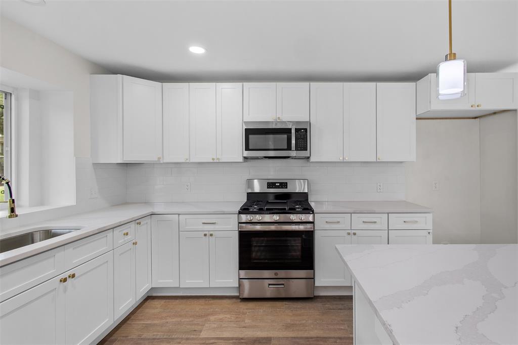 2816 Quail Ridge Drive Carrollton, TX 75006 - Photo 10 of 33 Kitchen featuring stainless steel appliances, white cabinets, light stone counters, hanging light fixtures, and recessed lighting
