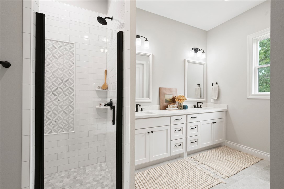 13291 Hopes Creek Road College Station, TX 77845 - Photo 16 of 45 Bathroom featuring a shower stall, double vanity, and light tile patterned flooring