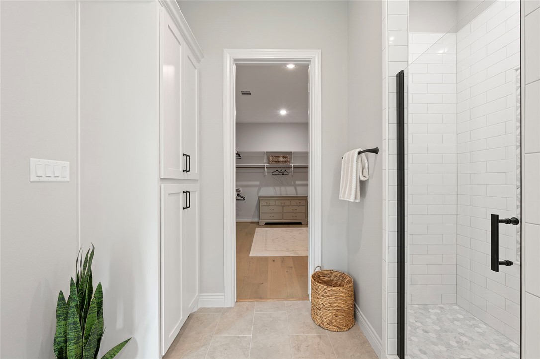 13291 Hopes Creek Road College Station, TX 77845 - Photo 17 of 45 Primary bathroom featuring a stall shower, light tile patterned flooring, a walk in closet, and recessed lighting