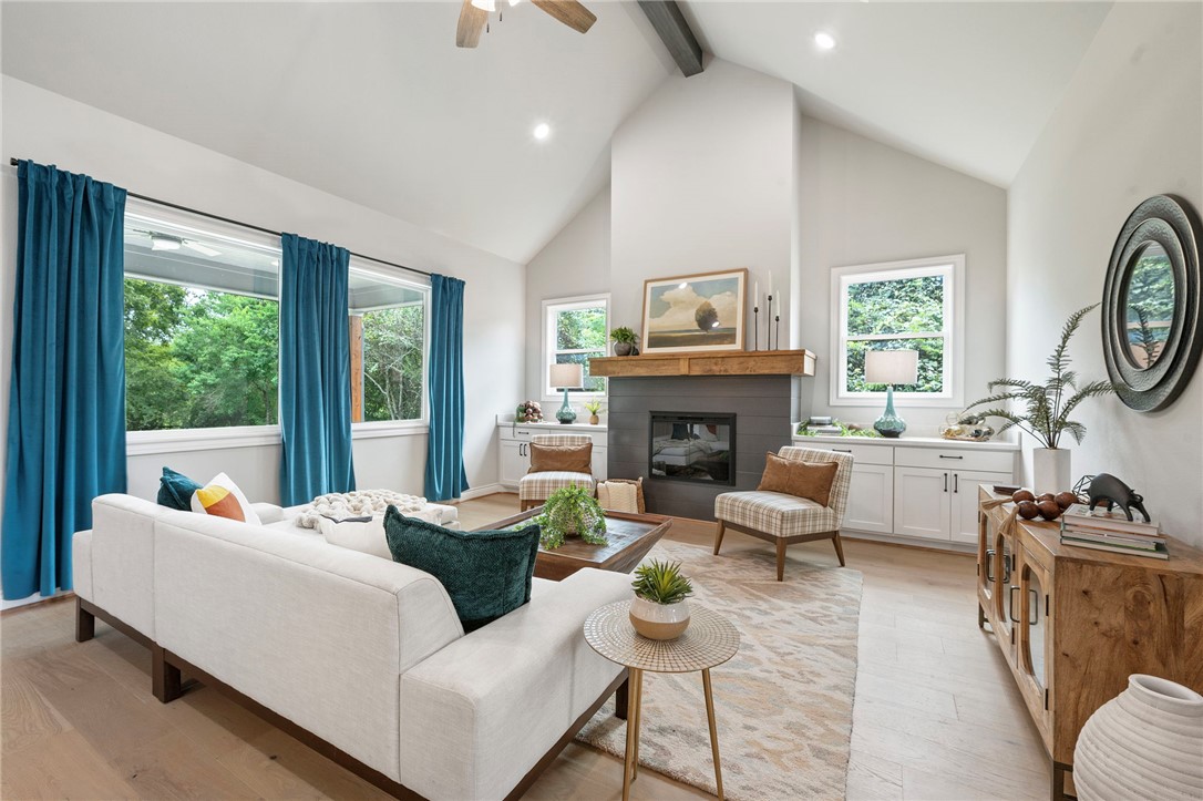 13291 Hopes Creek Road College Station, TX 77845 - Photo 9 of 45 Living room featuring beam ceiling, high vaulted ceiling, healthy amount of natural light, light wood-type flooring, and a glass covered fireplace