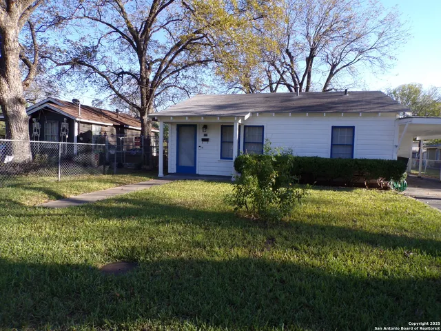 a view of a house with a yard potted plants and a large tree