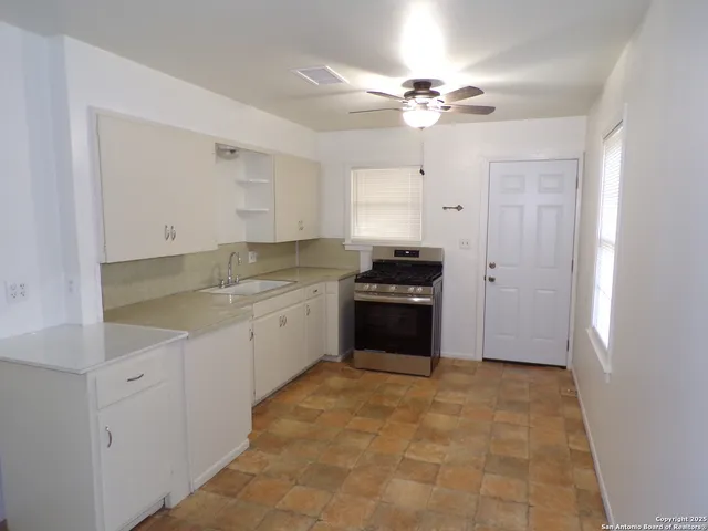 a large white kitchen with a sink and cabinets