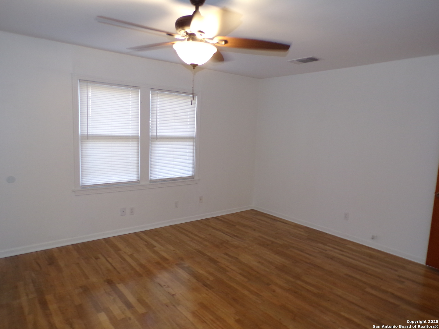 409 Bohme Street Uvalde, TX 78801 - Photo 3 of 9 a view of empty room with wooden floor and fan